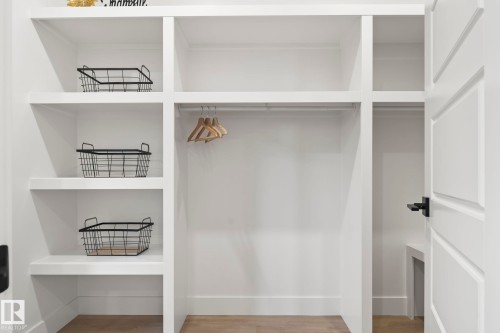 White built-in closet system featuring multiple open shelves, a hanging rod, and base trim - 13152 187 Avenue, Edmonton, AB 