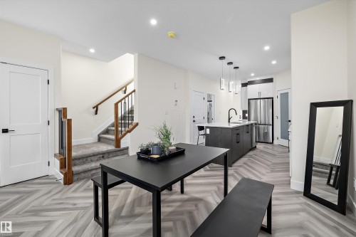 Open-concept living space with herringbone wood-finish flooring - 8319 81 Avenue Nw, Edmonton, AB 