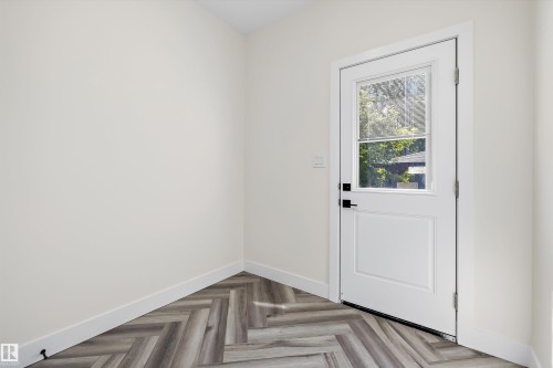 Entry door with frosted glass window, black hardware, and crisp white trim - 8319 81 Avenue Nw, Edmonton, AB 