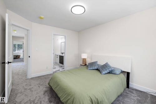 Bedroom featuring plush gray carpeting, white walls, and a contemporary ceiling light fixture - 8319 81 Avenue Nw, Edmonton, AB 