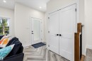 Entryway featuring wood-finish flooring in a herringbone pattern, a contemporary front door with frosted glass, and white double-panel doors - 8319 81 Avenue Nw, Edmonton, AB 