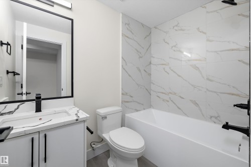 Bathroom featuring a white vanity with a patterned countertop, a built-in rectangular sink, and a matte black faucet - 8319 81 Avenue Nw, Edmonton, AB 