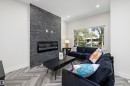 Living area featuring a floor-to-ceiling slate-style accent wall with an integrated linear fireplace - 8319 81 Avenue Nw, Edmonton, AB 
