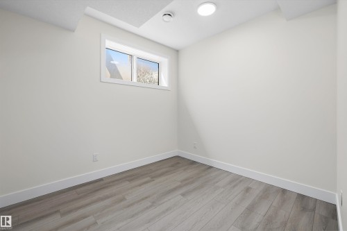 Room featuring light wood-finish flooring, white baseboards, a single window, recessed lighting, and light-colored walls - 8319 81 Avenue Nw, Edmonton, AB 
