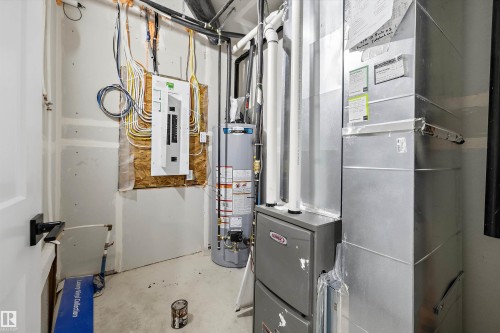 Utility room featuring a water heater, furnace, and electrical panel - 8319 81 Avenue Nw, Edmonton, AB 