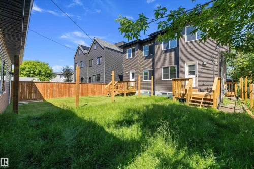 Expansive backyard with a wooden fence and a multi-level deck featuring wooden railings and steps - 8319 81 Avenue Nw, Edmonton, AB 