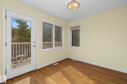 Room featuring wood-finish flooring, light-toned walls, and a ceiling-mounted light fixture - 