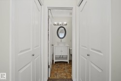 Bathroom featuring a white vanity with vessel sink, oval framed mirror, and three-light fixture - 