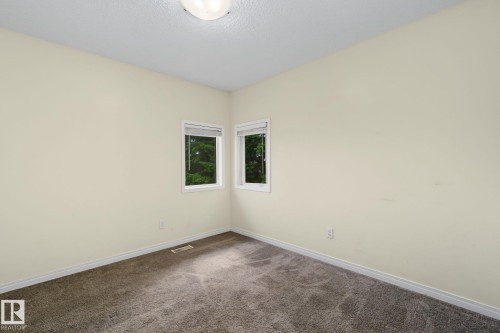 Neutral-toned interior room featuring two windows and plush carpet flooring - 4259 29 Avenue, Edmonton, AB 