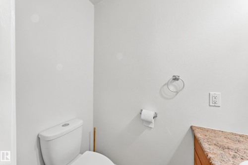 White commode with a chrome toilet paper holder - 1102 Millbourne Road E, Edmonton, AB 