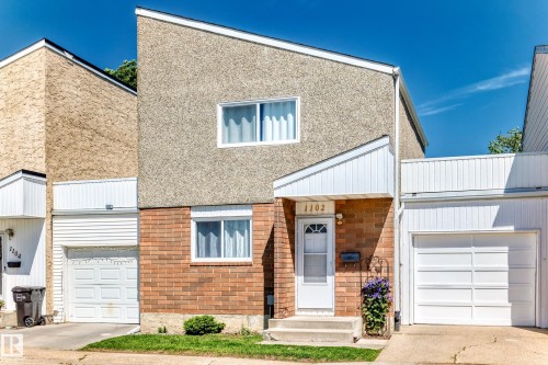 Exterior featuring a sloped roofline, a combination of brick and textured stucco siding, and multiple white-framed windows - 1102 Millbourne Road E, Edmonton, AB 