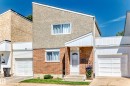 Exterior featuring a sloped roofline, a combination of brick and textured stucco siding, and multiple white-framed windows - 1102 Millbourne Road E, Edmonton, AB 