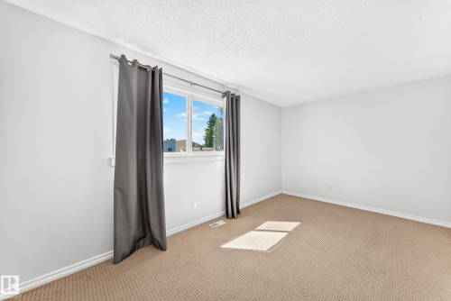Neutral-toned carpeting complements light wall paint - 1102 Millbourne Road E, Edmonton, AB 