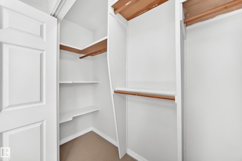 Walk-in closet featuring white painted shelving and hanging rods - 1102 Millbourne Road E, Edmonton, AB 