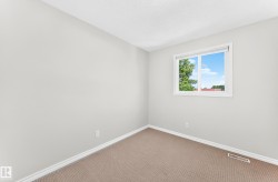 Neutral-toned room featuring a single window, light gray walls, and carpet flooring - 
