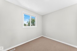 Neutral-toned room featuring a single window and textured carpeting - 