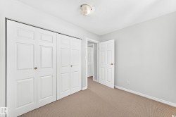Room featuring a wide closet with white paneled bifold doors and brass-finish hardware - 
