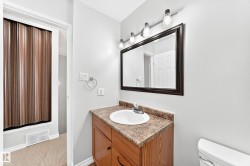 Vanity featuring a wood-finish cabinet, integrated sink, and stone-look countertop - 
