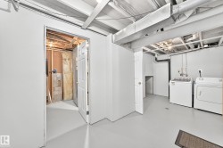 Utility area with painted concrete flooring, exposed ceiling joists, and a partial wall separating spaces - 
