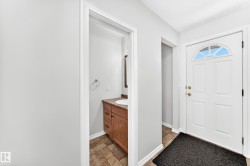 Entryway featuring a paneled front door with an arched transom window - 