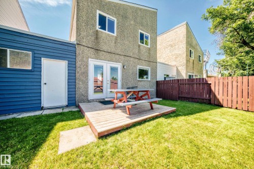 Expansive backyard featuring a manicured lawn, a raised wood deck, and a privacy fence - 1102 Millbourne Road E, Edmonton, AB 