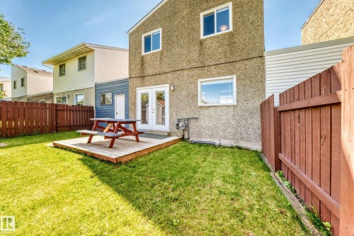 Expansive backyard featuring a manicured lawn, a wooden deck, and a full-height privacy fence - 1102 Millbourne Road E, Edmonton, AB 