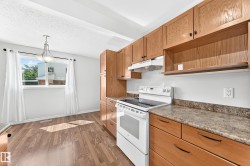 Kitchen featuring wood-finish cabinetry, a freestanding electric range, and laminate countertops - 