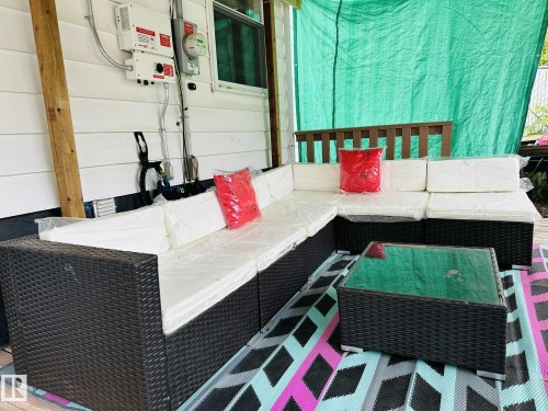 Outdoor patio area featuring a white siding wall and a wooden post - 12005 40 St, Edmonton, AB 