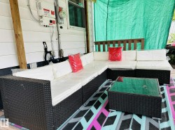 Outdoor patio area featuring a white siding wall and a wooden post - 