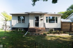 Ranch-style exterior featuring white horizontal siding and a dark foundation - 