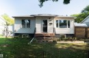 Ranch-style exterior featuring white horizontal siding and a dark foundation - 12005 40 St, Edmonton, AB 