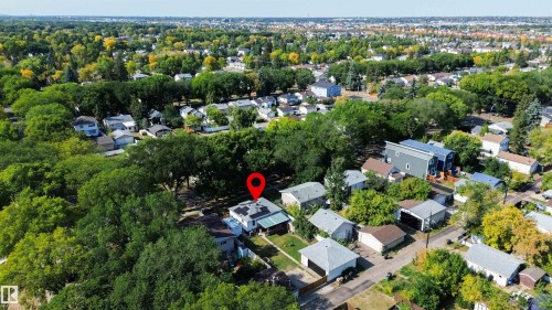 Residential property featuring solar panels on the roof and a surrounding neighborhood with mature trees - 12005 40 St, Edmonton, AB 