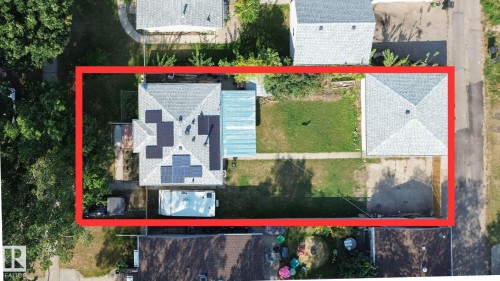 Aerial view showcasing the primary residence, a detached garage, and a spacious backyard - 12005 40 St, Edmonton, AB 