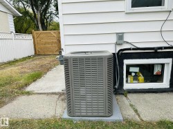 Exterior siding with a basement window and a contemporary air conditioning unit - 