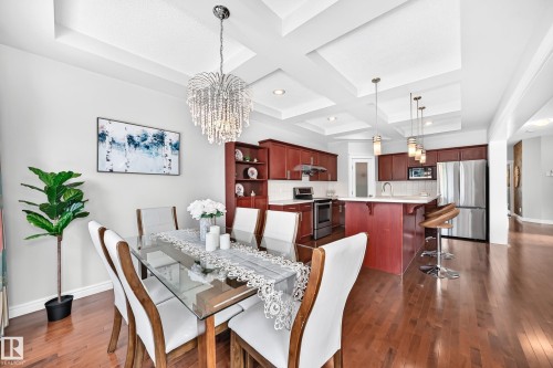 Dining area with a sophisticated crystal chandelier and tray ceiling detail - 1330 114B Street, Edmonton, AB 