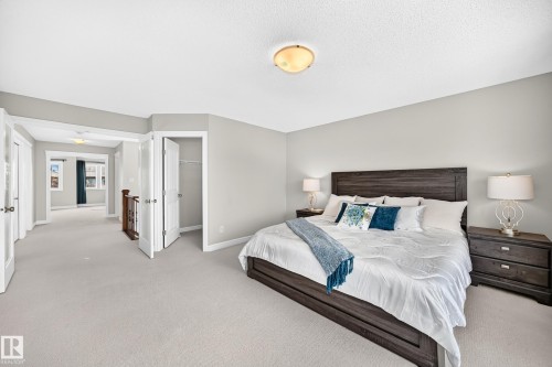 Spacious carpeted room with light grey walls and a ceiling-mounted light fixture - 1330 114B Street, Edmonton, AB 