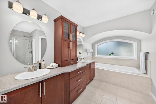 Dual vanity with wood cabinetry, light-toned countertops, and under-mount sinks - 1330 114B Street, Edmonton, AB 