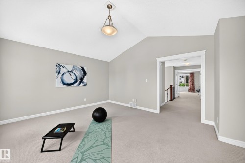 Spacious room featuring vaulted ceilings, light-toned carpeting, and neutral wall tones - 1330 114B Street, Edmonton, AB 