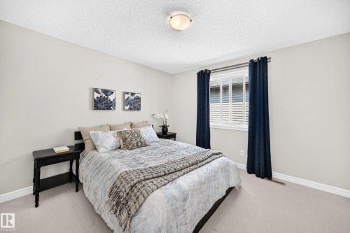 Bedroom featuring light neutral wall paint, white trim, and light-colored carpet flooring - 1330 114B Street, Edmonton, AB 