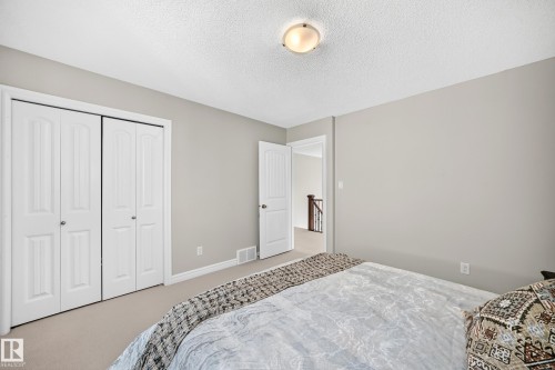 Carpeted room with light grey walls, white trim, and a textured white ceiling - 1330 114B Street, Edmonton, AB 
