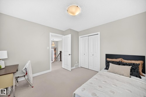 Neutral-toned room featuring light gray walls, plush carpeting, and white baseboards - 1330 114B Street, Edmonton, AB 