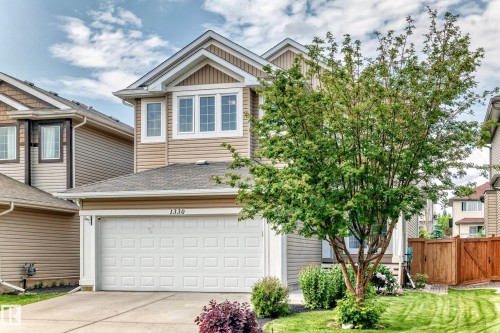 Two-story residential exterior featuring beige horizontal siding and vertical panel accents - 1330 114B Street, Edmonton, AB 