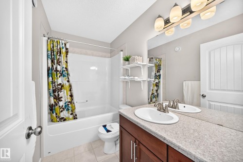 Full bathroom featuring a double vanity with an integrated countertop and dual oval sinks - 1330 114B Street, Edmonton, AB 