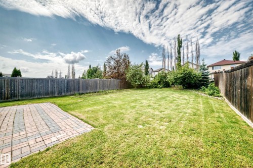 Expansive green lawn with a patio composed of rectangular pavers in varying shades - 1330 114B Street, Edmonton, AB 