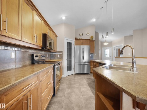 Kitchen featuring wood cabinetry, stainless steel appliances, and a double basin sink - 45 Willow Wood Lane, Stony Plain, AB 