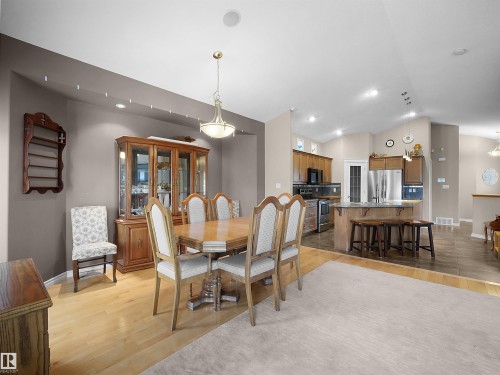 Dining area featuring wood-finish flooring and a contemporary chandelier - 45 Willow Wood Lane, Stony Plain, AB 
