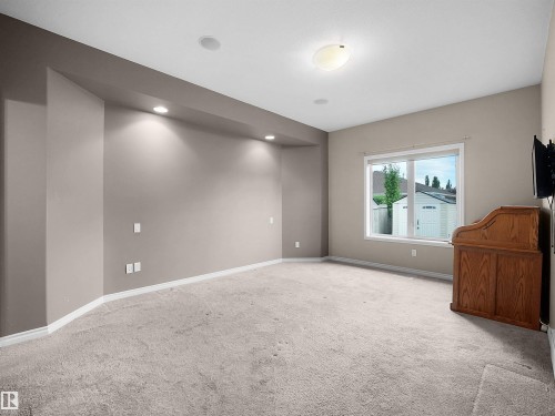 Carpeted room featuring neutral wall tones, recessed lighting, a large window, and white trim - 45 Willow Wood Lane, Stony Plain, AB 