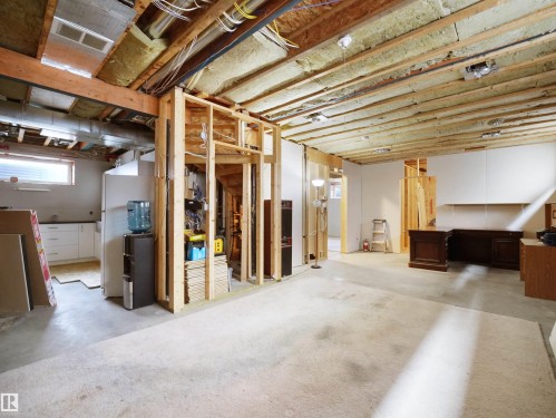 Spacious lower level offering significant customization potential, featuring exposed ceiling joists and insulation, partial drywall installation, and framed interior walls - 45 Willow Wood Lane, Stony Plain, AB 