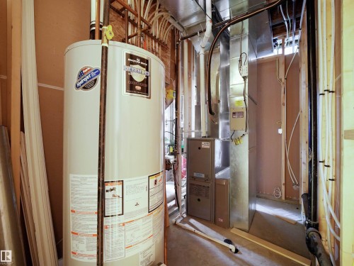 Utility space featuring a water heater, furnace, and exposed ductwork - 45 Willow Wood Lane, Stony Plain, AB 