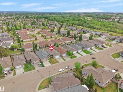 Aerial perspective showcasing a residential neighborhood with a tree-lined perimeter - 45 Willow Wood Lane, Stony Plain, AB 